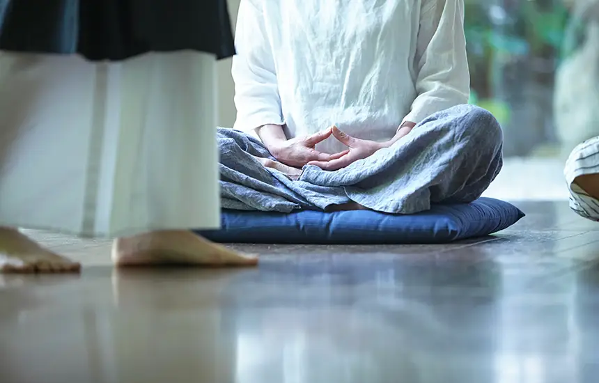 People calmly practicing Zazen in a temple hall.