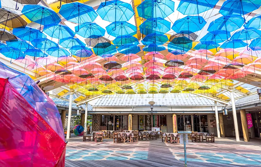 Contemporary sculptures and objects that blend into the landscape of a city park or square. The photo should show people strolling and relaxing as they engage with the art, expressing the feeling of freedom that comes from art being a part of daily life.
