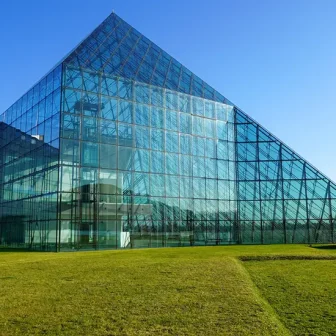 A museum with architectural design that blends into a vast natural landscape. Inside, natural light pours in, beautifully illuminating the artwork. The photo expresses the sense of openness and healing that comes from the fusion of nature and art.