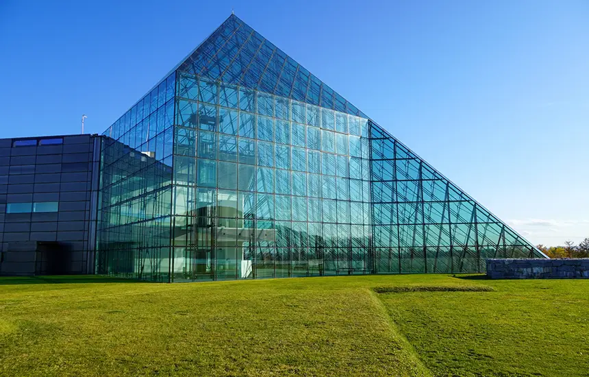 A museum with architectural design that blends into a vast natural landscape. Inside, natural light pours in, beautifully illuminating the artwork. The photo expresses the sense of openness and healing that comes from the fusion of nature and art.